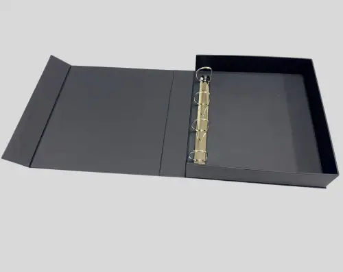 A black binder with a three-ring mechanism, lying open on a flat surface.